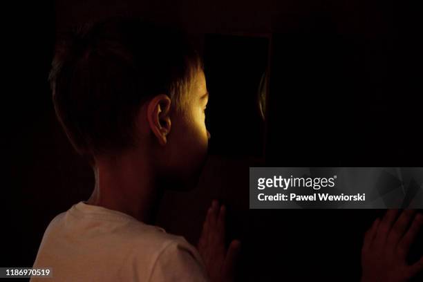boy looking through hole in wall - kikhål bildbanksfoton och bilder