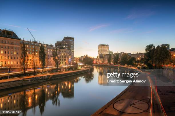 vienna evening cityscape reflecting in danube river - austria skyline stock pictures, royalty-free photos & images