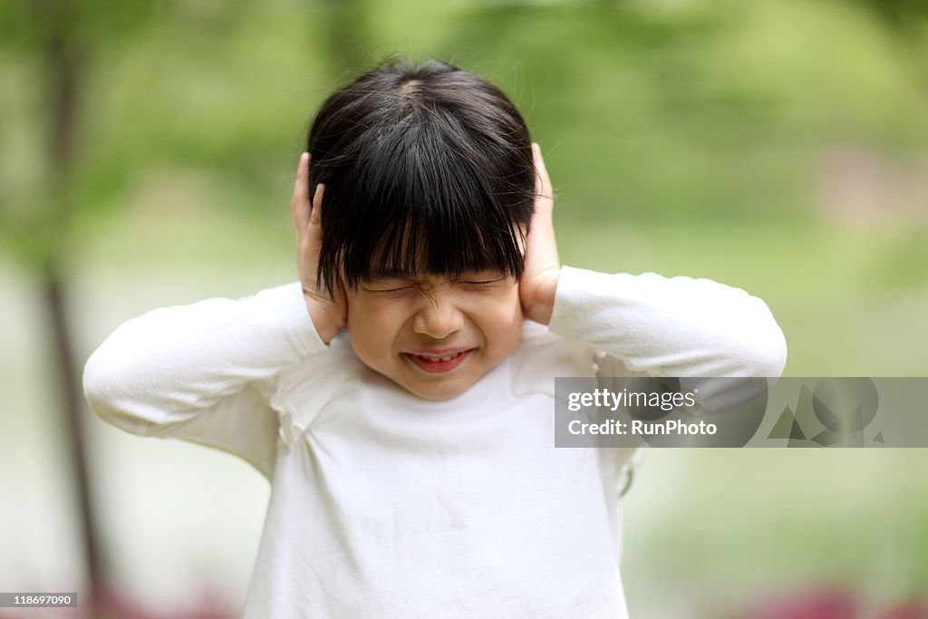 Image of child playing,girl have closed her ears