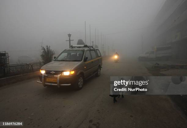 Passenger cab moves as dense fog engulfs the area in Srinagar,Kashmir on December 07, 2019.The air and road traffic was disrupted as most of the...