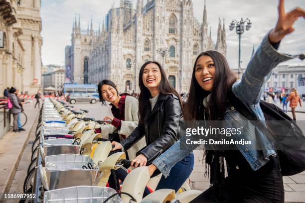 gruppo di amici felici e positivi seduti in bici - milan street fashion 2019 foto e immagini stock
