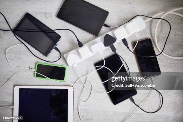 digital devices plugged in to a extension lead - cable stock-fotos und bilder