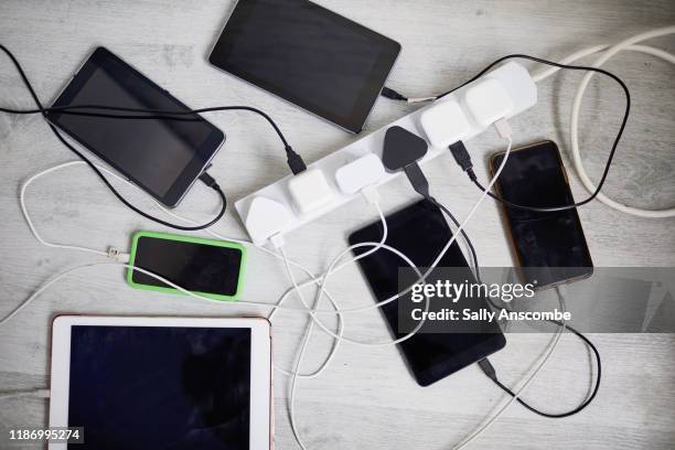 digital devices plugged in to a extension lead - computer cable foto e immagini stock