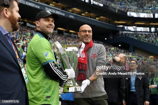 Seattle Sounders FC legend Chad Marshall and Toronto FC legend Danny Dichio take the Philip F. Anschutz Trophy onto the field during a game between...
