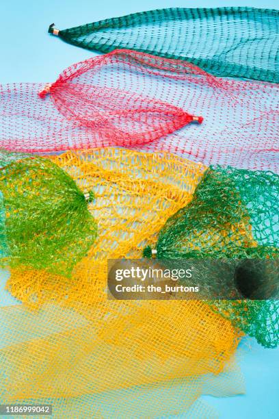 colorful packaging nets on blue colored background, directly above shot of disposable plastic mesh - food covered stock pictures, royalty-free photos & images