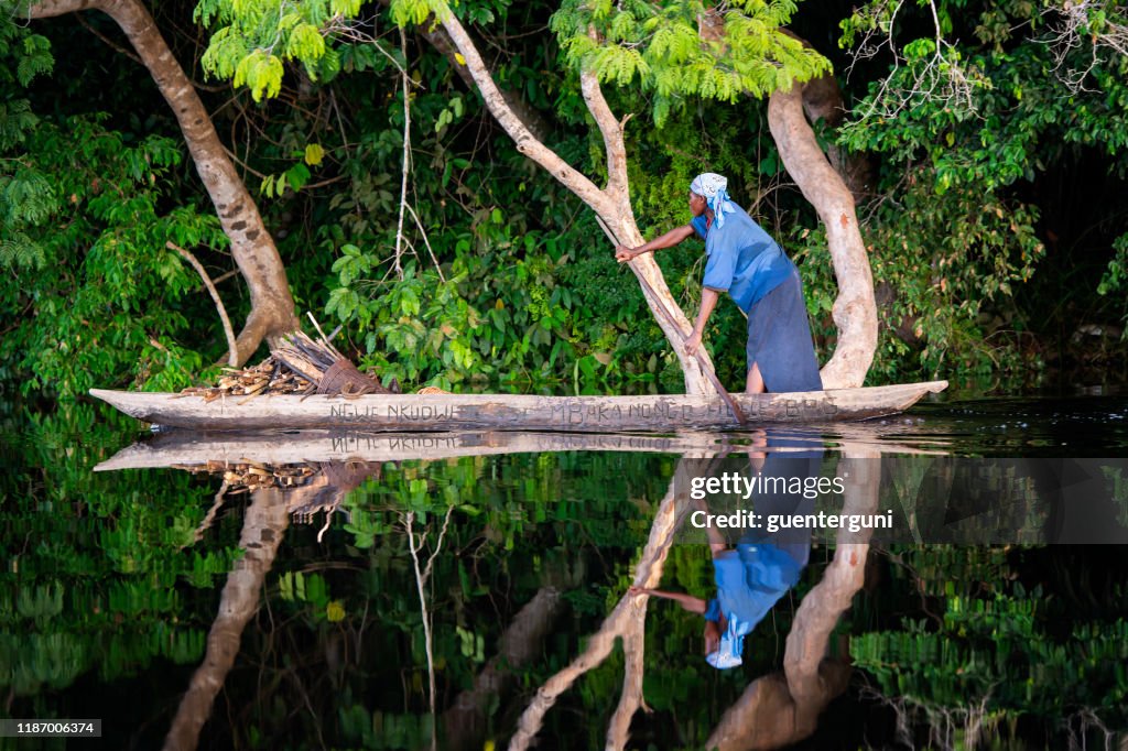 La femme pagaie dans une pirogue sur le fleuve du Congo