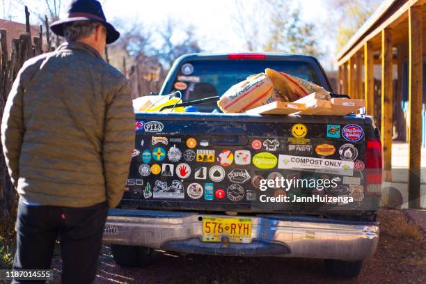 santa fe, nm: man reading pickup truck's bumper stickers - bumper sticker stock pictures, royalty-free photos & images