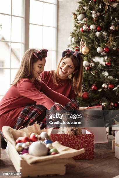 glückliches kleines mädchen öffnet ihr weihnachtsgeschenk und immer einen welpen - dog knotted in woman stock-fotos und bilder