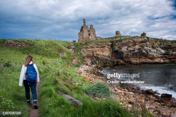 hiking toward ruins on the fife coastal walk - scotland castle stock pictures, royalty-free photos & images