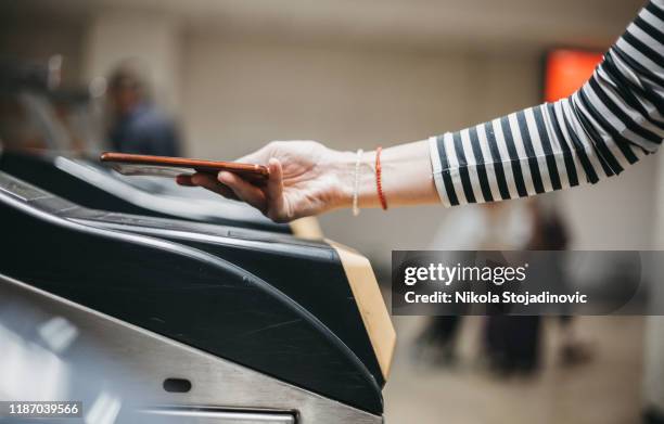 woman checking out at metro station using mobile phone - ticket counter stock pictures, royalty-free photos & images