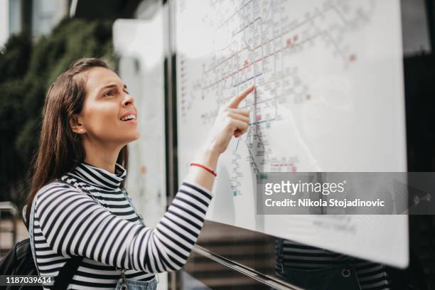 woman near the subway map, looking for the direction - looking at subway map stock pictures, royalty-free photos & images