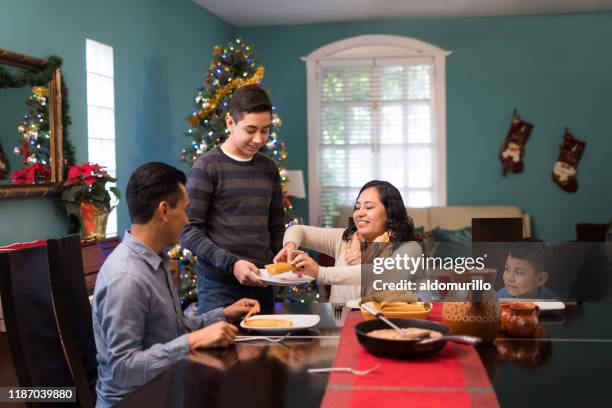 mexican family on christmas eating together - mexican christmas stock pictures, royalty-free photos & images