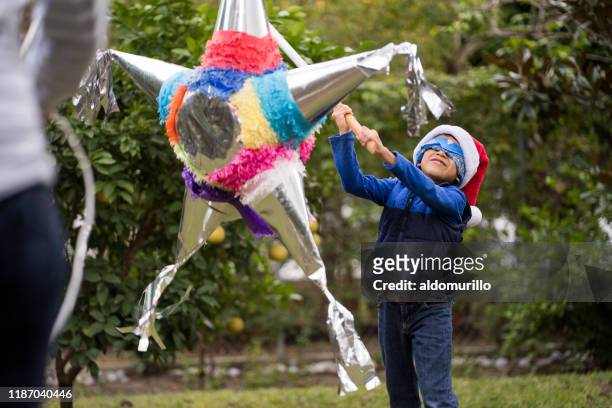 kid hitting a piñata on christmas - mexican christmas stock pictures, royalty-free photos & images