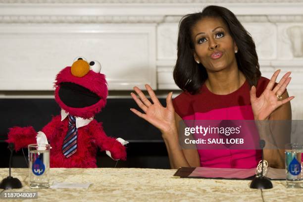 In this file photo taken on October 30, 2013 US First Lady Michelle Obama dances alongside Sesame Street character Elmo during an event announcing...