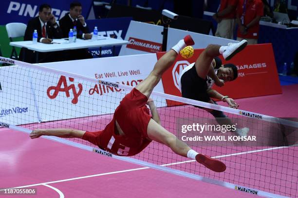 Thailand's Jirasak Pakebuangoen attempts to hit the ball past against Myanmar's Aung Thu Aung during the sepak takraw match at the SEA Games at the...