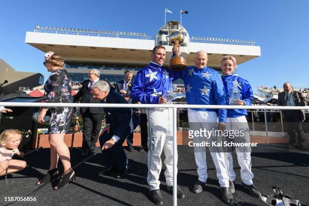 Blair Orange driving Cruz Bromac and trainers Mark Purdon and Natalie Rasmussen pose with the New Zealand Cup and the trophies for the best driver...