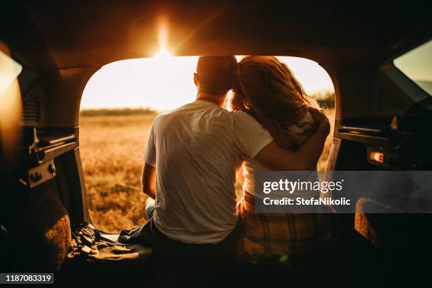 couple sitting in trunk of the car - car love stock pictures, royalty-free photos & images