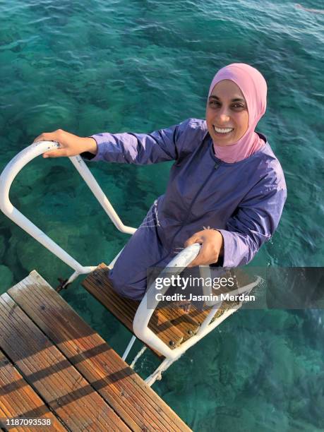 muslim woman swimming in sea - burkini bildbanksfoton och bilder