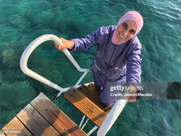 muslim woman swimming in sea - burkini bildbanksfoton och bilder