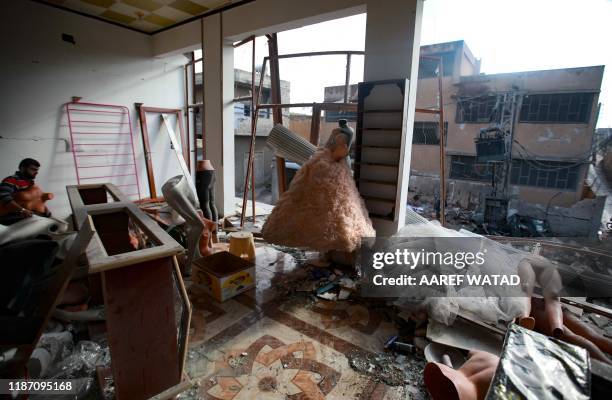 Wedding dresses are seen in the destroyed window of a bridal shop in a damaged building in Balyun in Syria's northwestern Idlib province, on December...