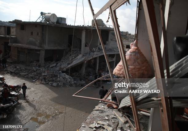 Wedding dress is seen in the destroyed window of a bridal shop in a damaged building in Balyun in Syria's northwestern Idlib province, on December 8...