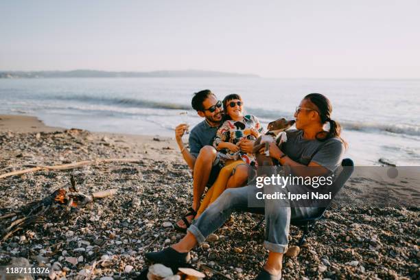 family with dog having fun at beach camping site - eltern sonnenbrille sonne lachen stock-fotos und bilder