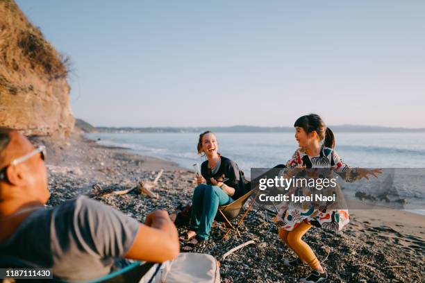 preschool girl dancing for her family at beach camping site - children dancing outside stockfoto's en -beelden