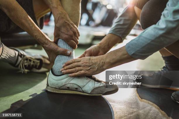 close up of assistance in sports injury at gym. - distenção imagens e fotografias de stock
