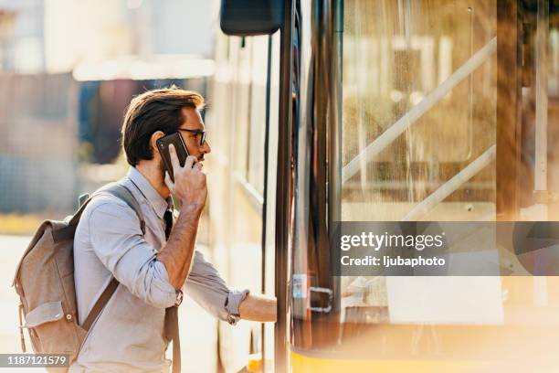 homme d'affaires entrant dans un autobus - entering photos et images de collection