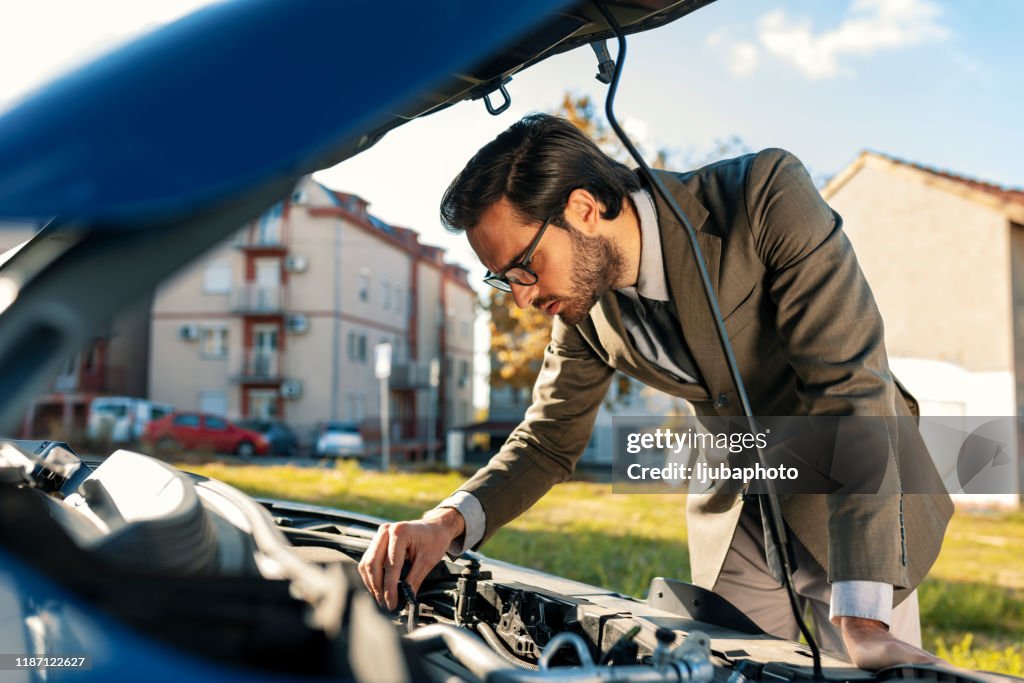 Uomo preoccupato che guarda l'auto della macchina rotta