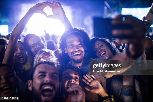 glückliche freunde, die nachts ein selfie auf dem musikfestival machen. - rock fest stock-fotos und bilder