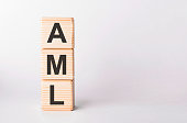 AML letters of wooden blocks in pillar form on white background, copy space