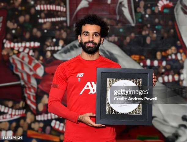 Mohamed Salah of Liverpool pose for a picture with his Ballon D'or Nominations at Melwood Training Ground on November 12, 2019 in Liverpool, England.