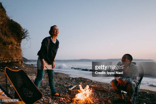 enjoying sunset campfire at beach, tokyo bay - アウトドア　日本人 ストックフォトと画像