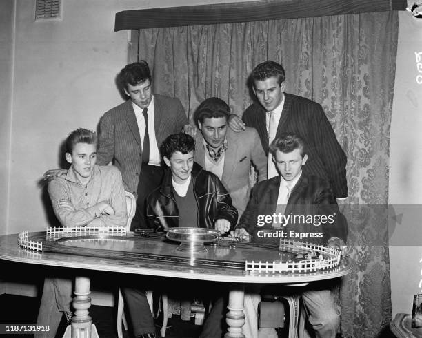 British rock and roll singers Billy Fury , Marty Wilde, Dickie Pride , Vince Eager, and Kenny Packwood playing with a toy car track with British...