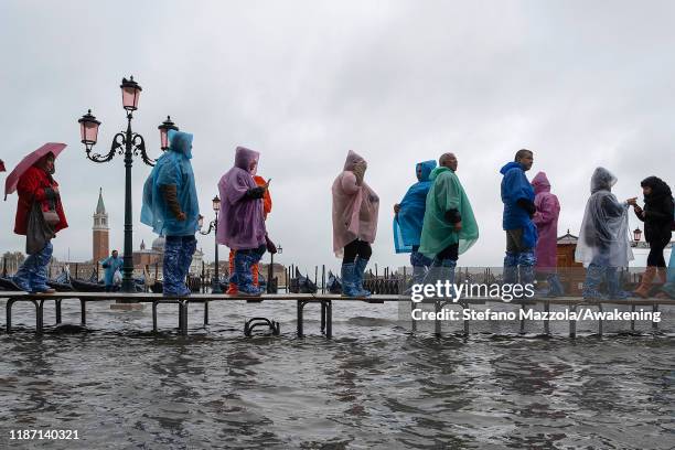 Tourists walk in high water Piazza San Marco in Piazza San Marco on November 12, 2019 in Venice, Italy. High tide, or acqua alta as it is more...