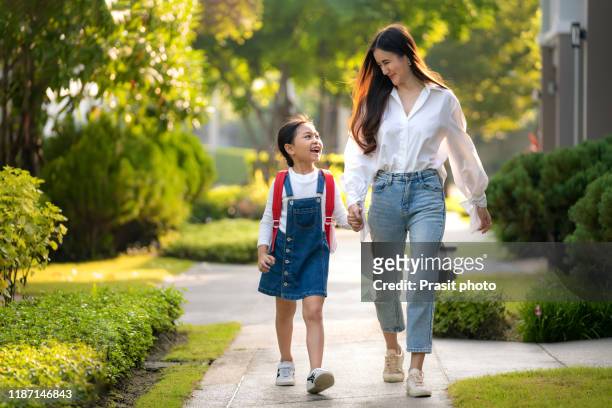 happy asian mother and daughter preschool student walking to school. beginning of lessons. first day of fall. parenthood or love and bonding expression concept. - mother daughter holding hands stock pictures, royalty-free photos & images