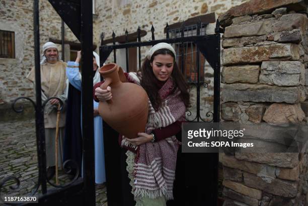 Woman dressed in a traditional costume carries a water jug during the live nativity scene in the small village of Oncala, north of Spain. Villagers...