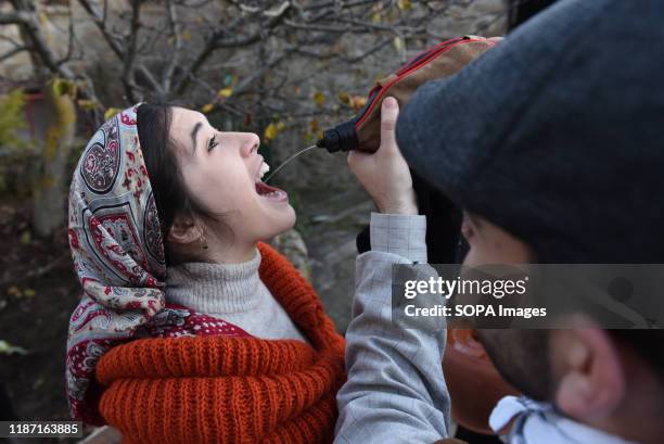 Woman dressed in a traditional costume drinks wine during the live nativity scene in the small village of Oncala, north of Spain. Villagers of the...