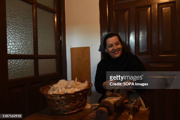 Woman dressed in traditional costume seen sewing during the live nativity scene in the small village of Oncala, north of Spain. Villagers of the...