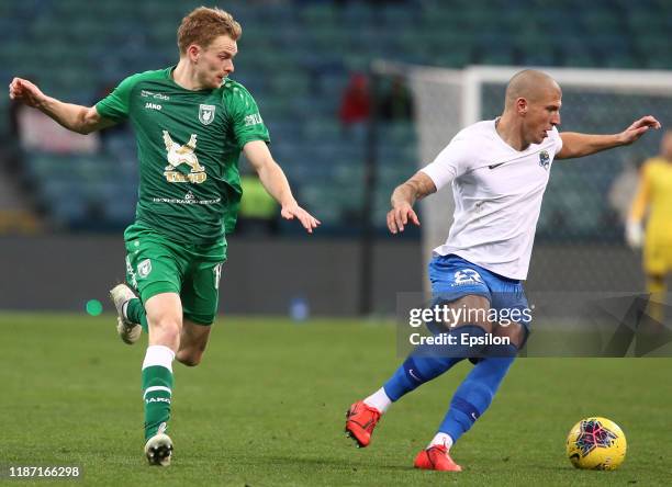 Ivan Miladinovic of PFC Sochi vies for the ball with Pavel Mogilevets of FC Rubin Kazan during the Russian Premier League match between PFC Sochi v...