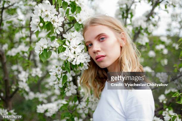 blond haired young woman among white blossoms - cosmetique naturel photos et images de collection