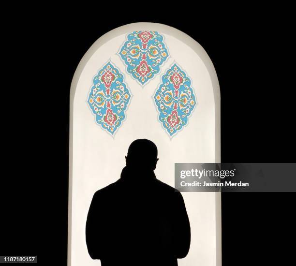 silhouette rear view of imam praying in mosque - isfahan imam stock pictures, royalty-free photos & images