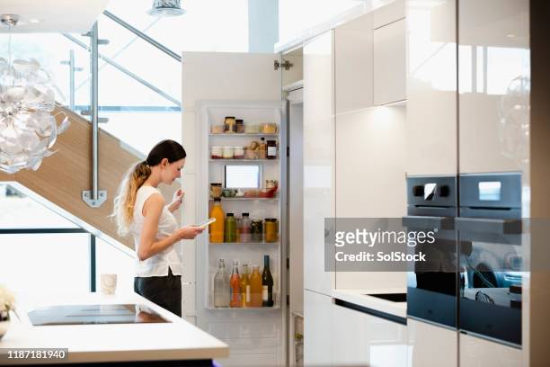 ¡usando mi refrigerador inteligente! - cocina electrodomésticos fotografías e imágenes de stock