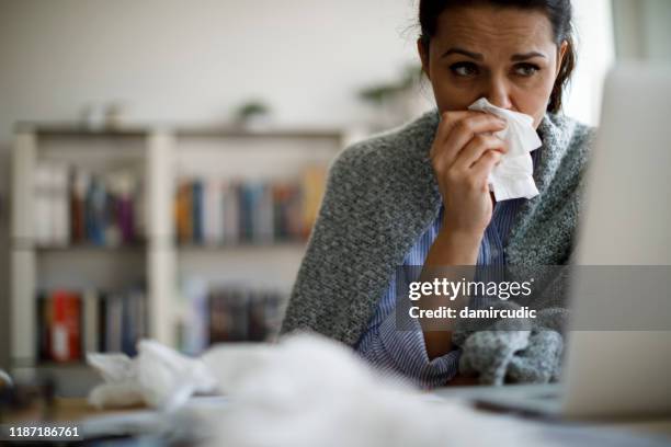 woman blowing her nose - sick woman blowing nose stock pictures, royalty-free photos & images