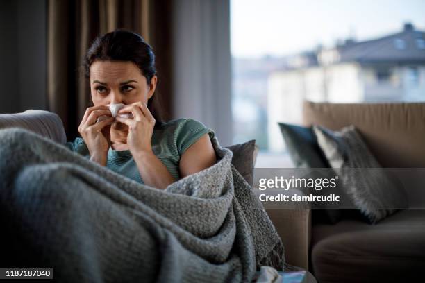 woman blowing her nose - respiratory disease stock pictures, royalty-free photos & images