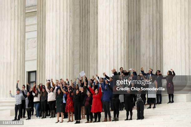 People raise their fists in the air and cheer on the steps of the U.S. Supreme Court after attending arguments in a case about the Deferred Action on...