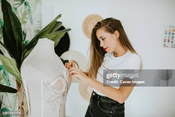 young fashion designer making a wedding dress - mannequin blonde stockfoto's en -beelden