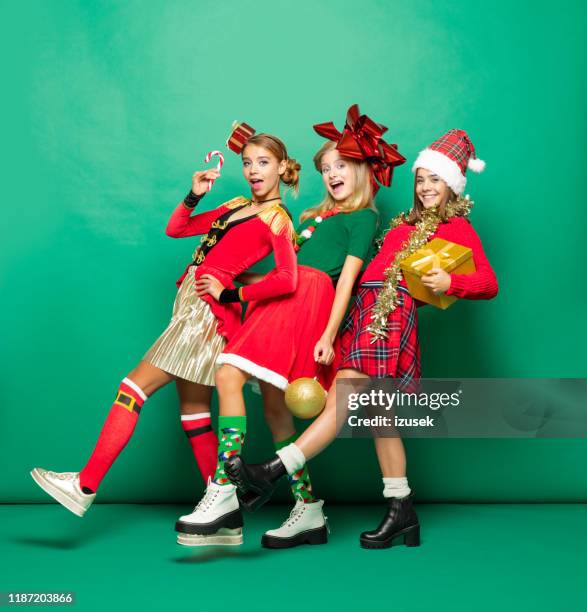 grappige kerst portret van drie tiener meisjes tegen groene achtergrond - kneesock stockfoto's en -beelden