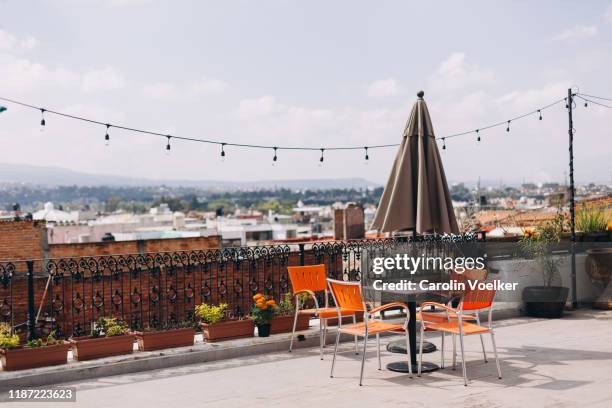 terrace with table and four chairs overlooking the morelia city center - dachterrasse stock-fotos und bilder
